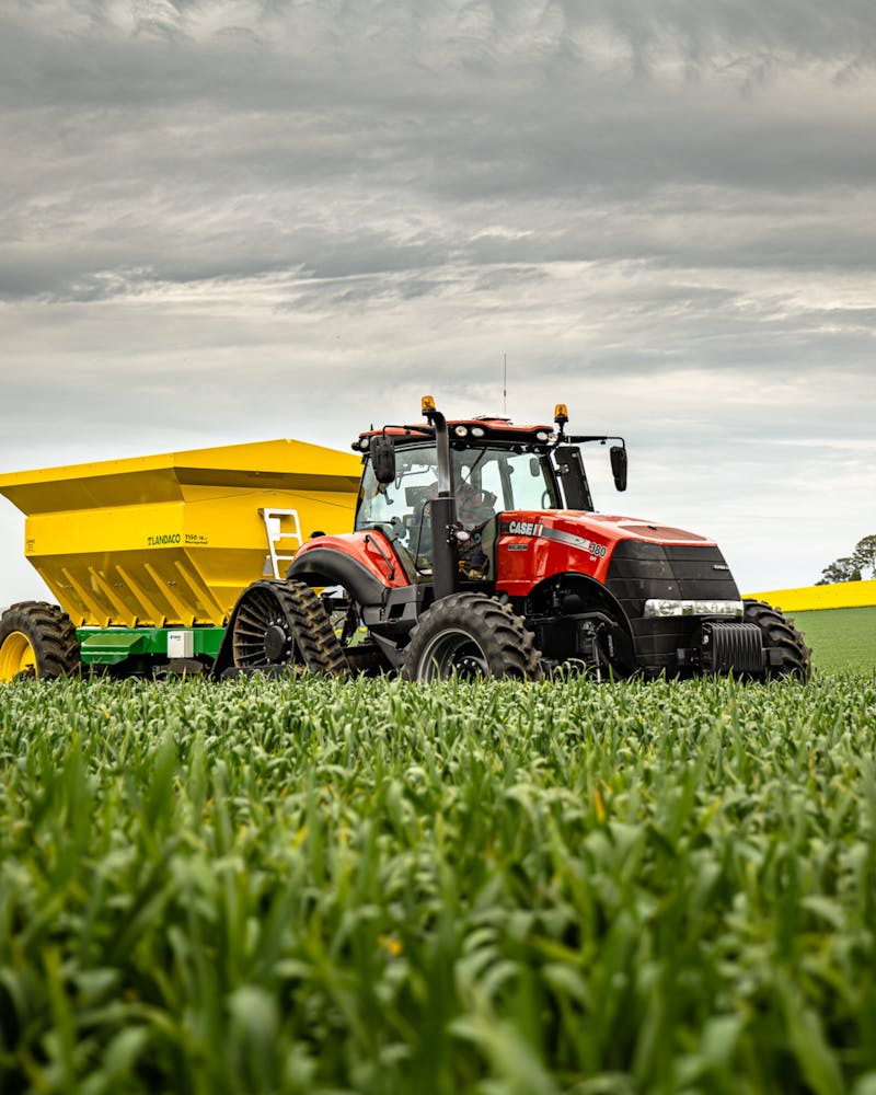 Red tractor working in a cornfield on a farm
